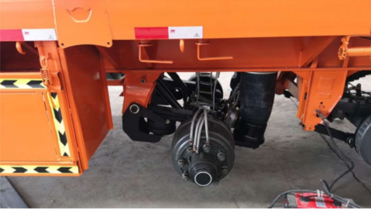 an axle on an orange trailer